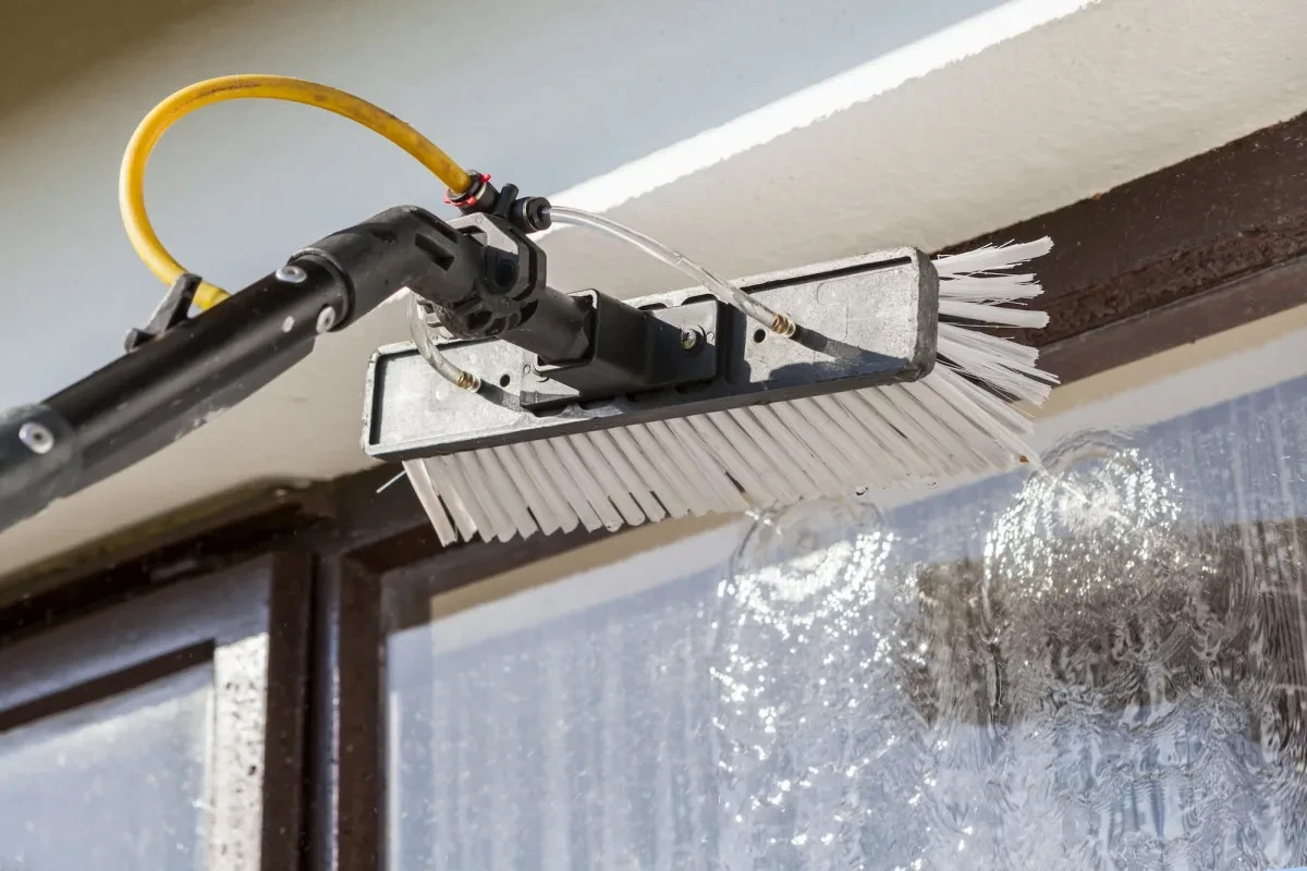 A window being cleaned with a purified-water pole brush