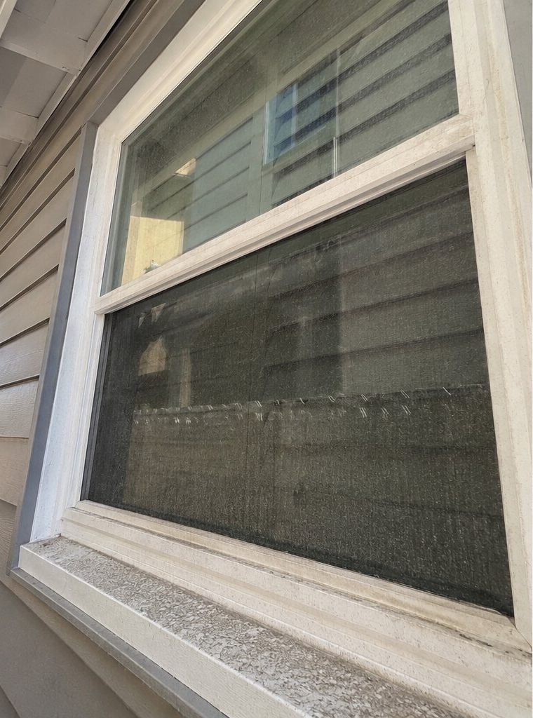 A hard-water-stained window before cleaning